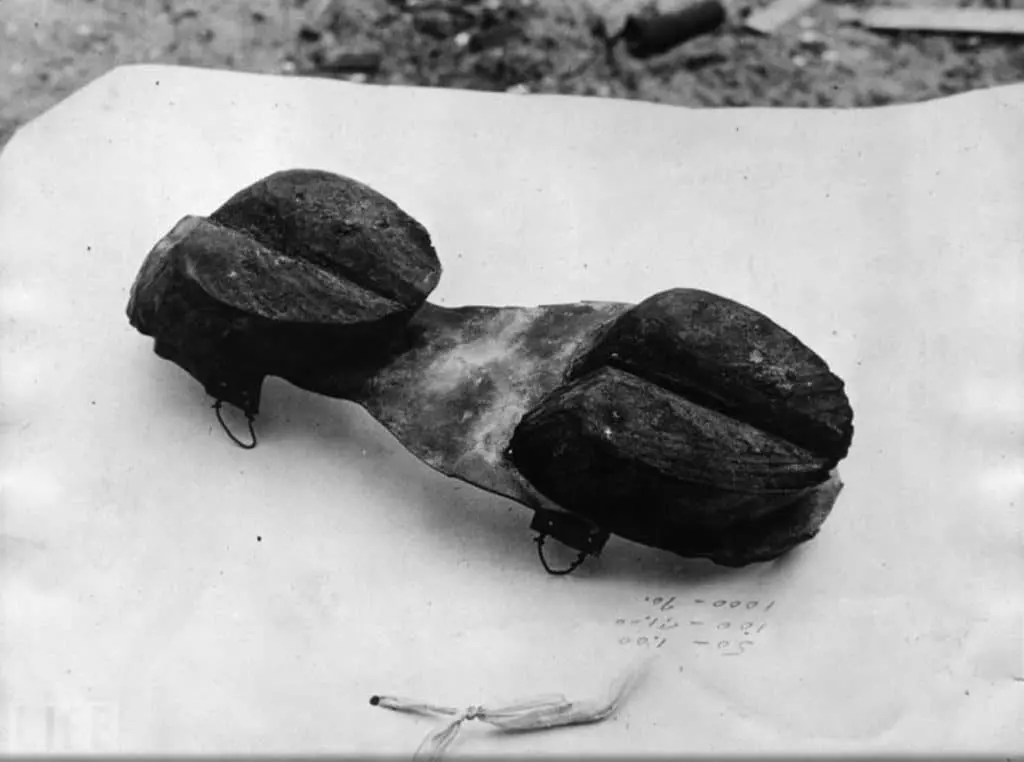 Black and white photo of a strap-on sole carved with a cow's cloven hoofprint at each end, used by moonshiners during Prohibition to hide their footprints