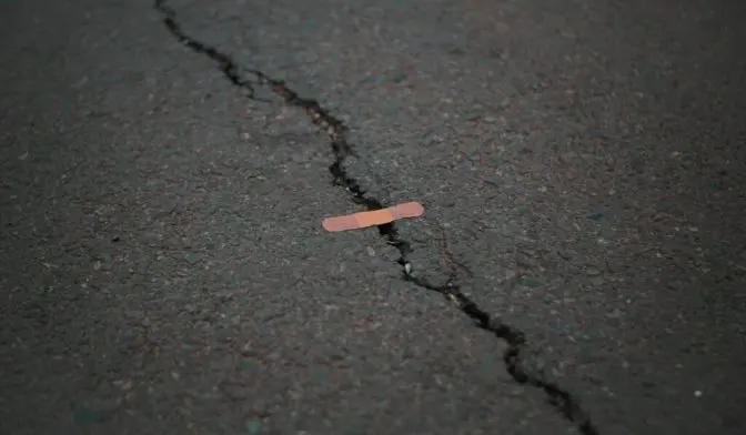 Crack in road with plaster/band-aid stuck over it